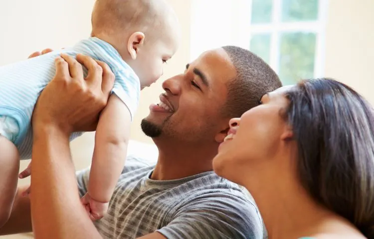 pareja latina cargando bebe